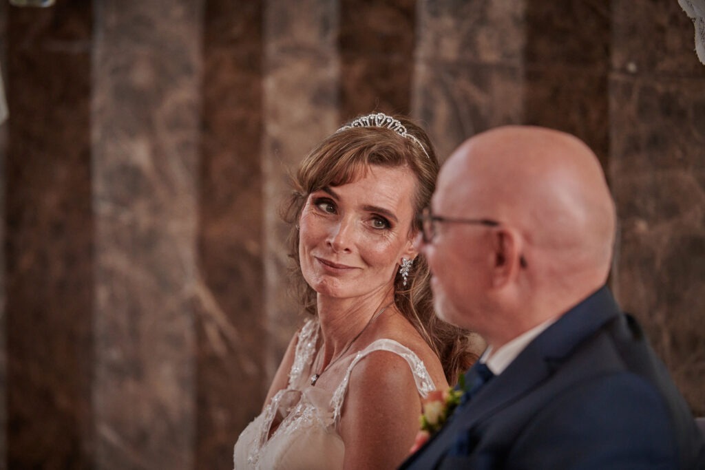 Eine Braut schaut ihrem Mann während der Trauung in die Augen; Aufgenommen von Der Hochzeitsfotograf Saarland